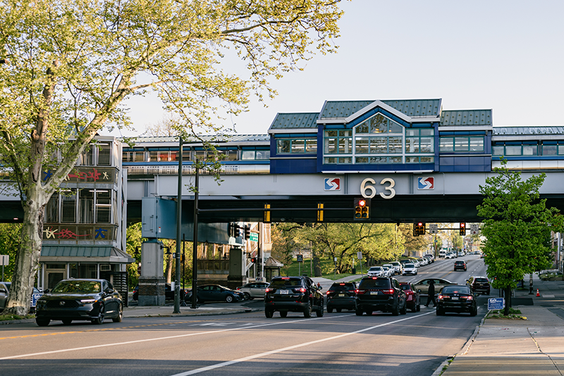 A photograph Philadelphia's 63rd Street bridge, where the Septa rail line crosses above the street. The number 63 is prominently displayed and there are cars on the street below.