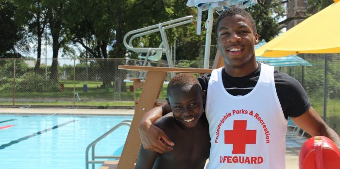 City of Philadelphia lifeguard standing with young boy